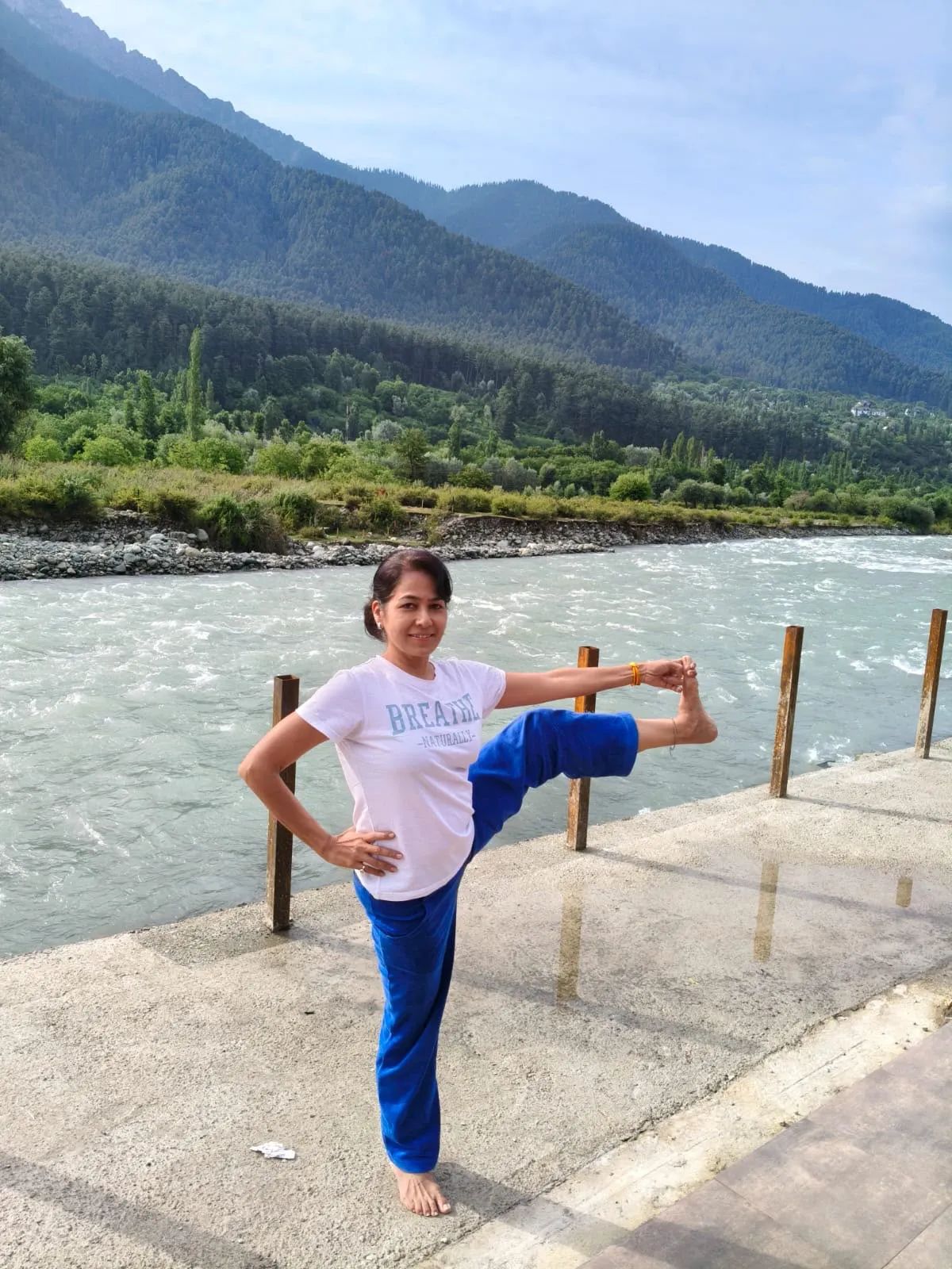 Vin in extended hand-to-big-toe pose by a mountain river